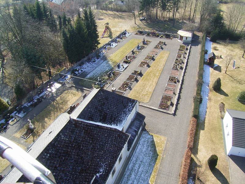 Von Kirchturm aus gesehen ber den Friedhof. Im Hintergrund ist noch die alte Leichenhalle zu sehen, die jedoch mit Hilfe der Dorfgemeinschaft(Pfarrei) Komplett neu gebaut wurde. 